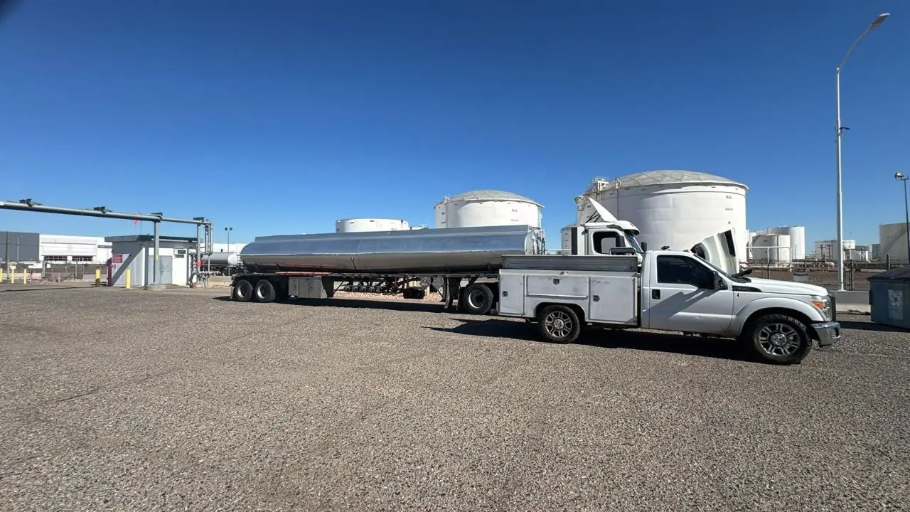 Camioneta de servicio junto a un tráiler tanque en una terminal de combustible en Phoenix